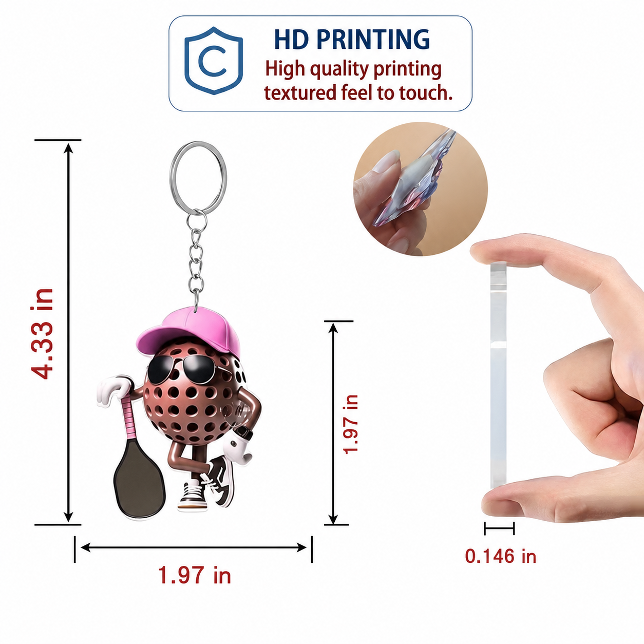 A small novelty keychain shaped like a spotted, faceless character wearing a pink cap and sunglasses, holding a paddle, shown with measurement labels and a hand holding a slim strip for scale. A badge at the top reads 'HD PRINTING High quality printing textured feel to touch.