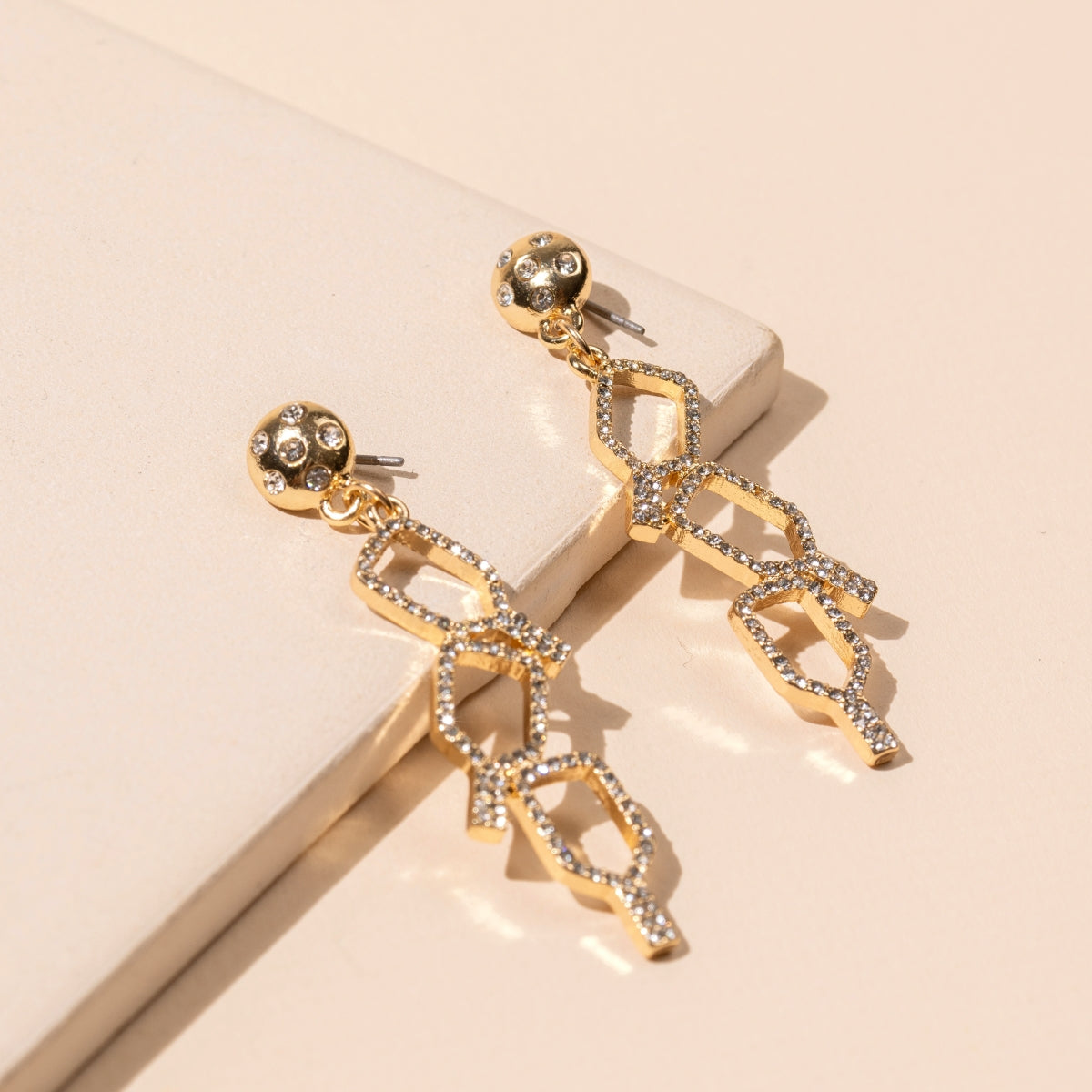 Close-up of linked gold pickleball earrings with rhinestones