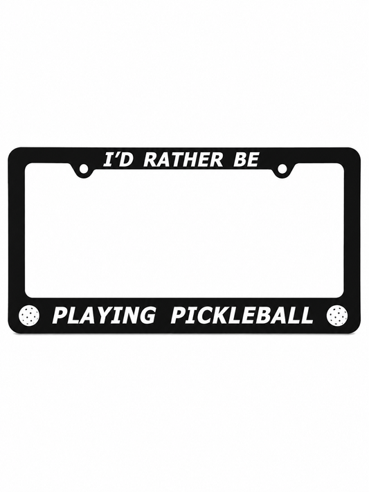 A black license plate frame with white text reading 'I'D RATHER BE PLAYING PICKLEBALL' and small white pickleball icons on the bottom corners, shown on a plain white background.