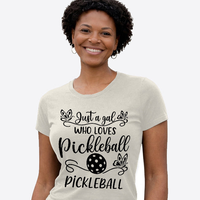 Woman wearing a t-shirt with 'Just a gal who loves Pickleball Pickleball' text and design.