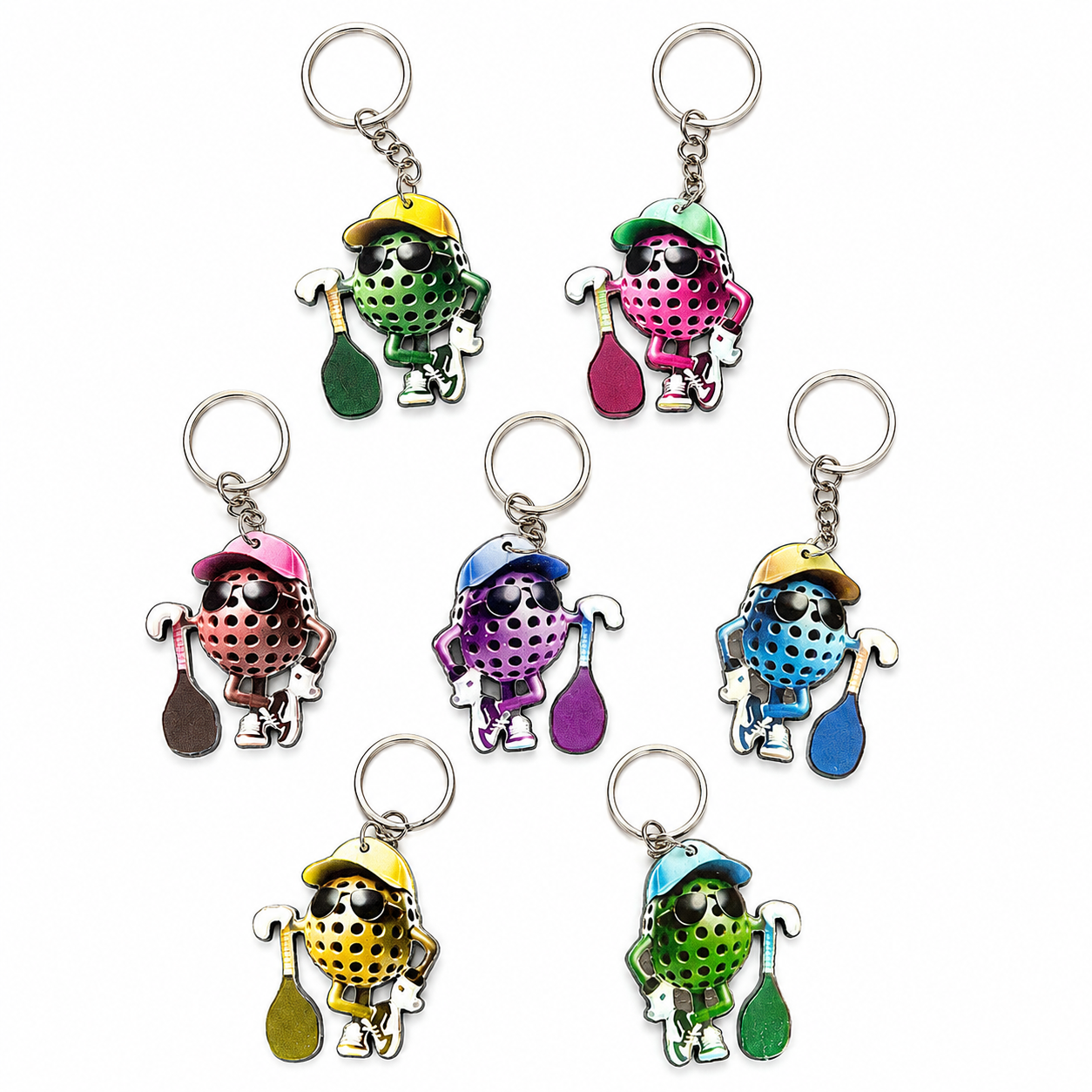 Seven colorful pickleball-themed metal keychains arranged on a plain white background. Each keychain features a cartoon paddle-shaped character wearing different colored helmets and holding paddle-shaped items.