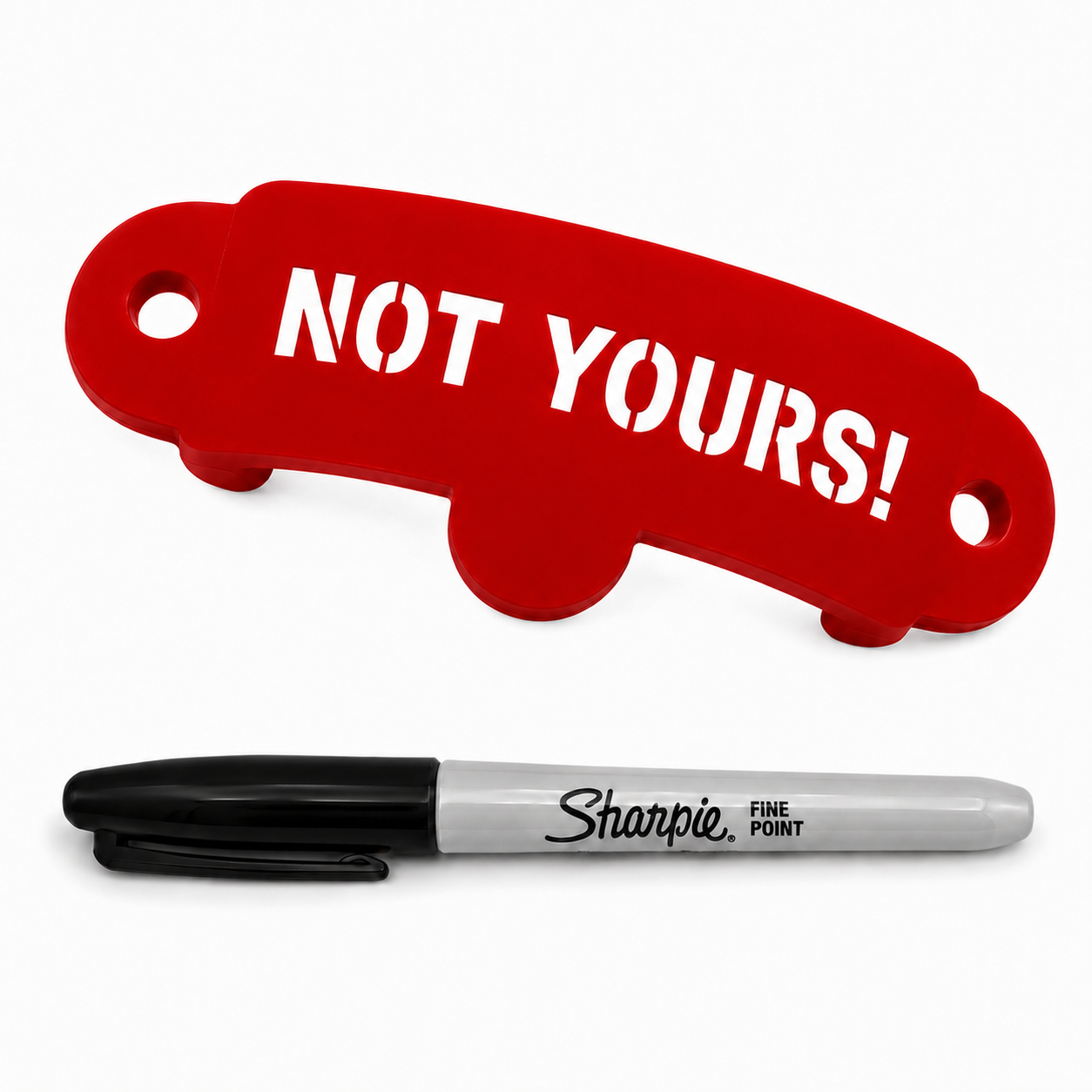 A red car-shaped keychain with the words 'NOT YOURS!' in white, shown above a black and silver Sharpie fine point marker on a white background.