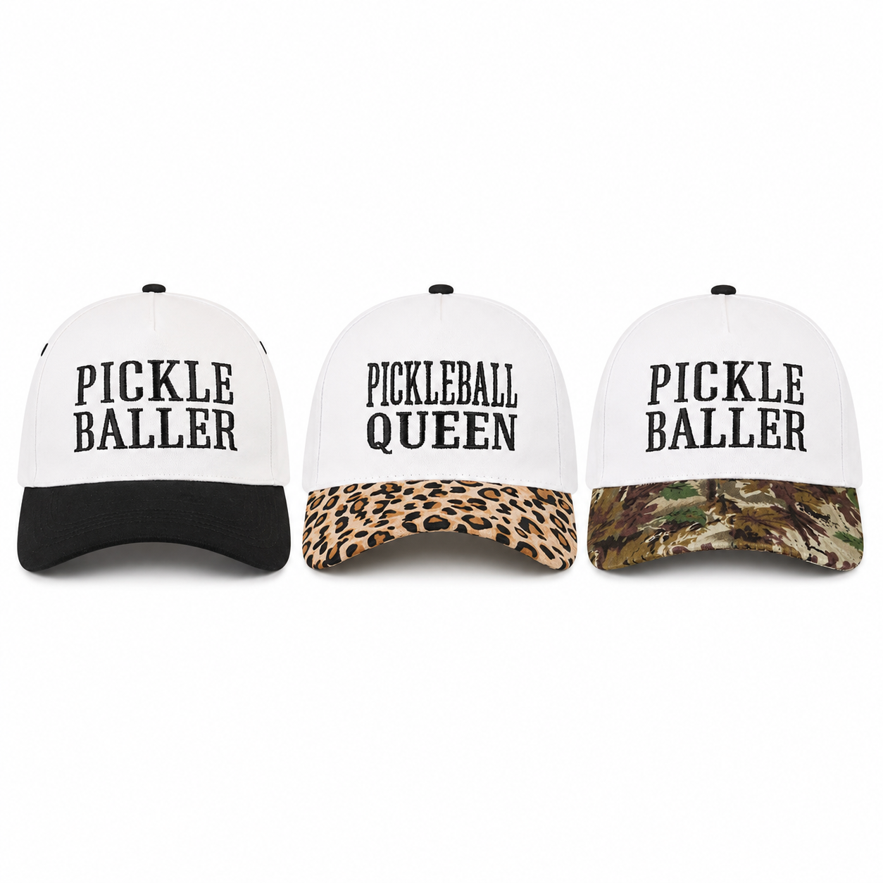 Three baseball caps shown side by side on a plain white background. Each cap has a white front panel with black text reading 'PICKLE BALLER' or 'PICKLEBALL QUEEN' and a contrasting black, leopard-print, and camouflage brim.