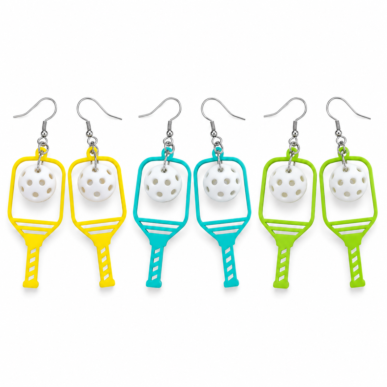 Six pairs of novelty drop earrings shaped like pickleball paddles, shown in yellow, light blue, and lime green, with white ceramic pickleballs and silver fishhook wires on a plain white background.