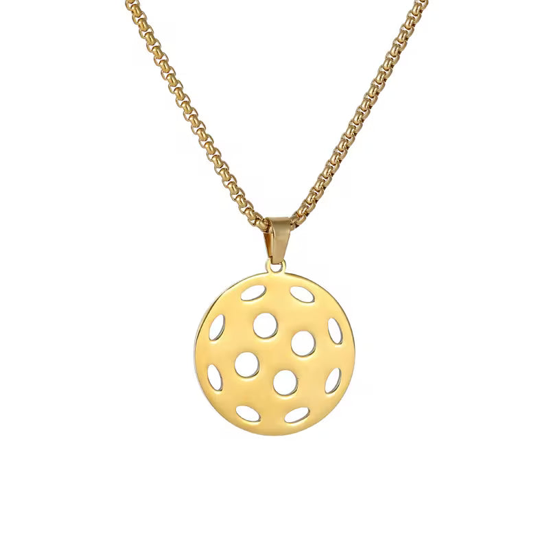 A gold necklace featuring a circular pendant with multiple cutout holes, suspended from a gold chain against a plain white background.