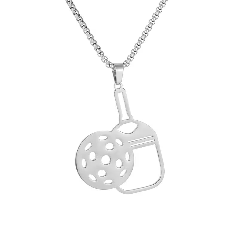 A silver pendant necklace featuring a cutout design of a teapot and a perforated round element, suspended from a silver box chain against a plain white background.