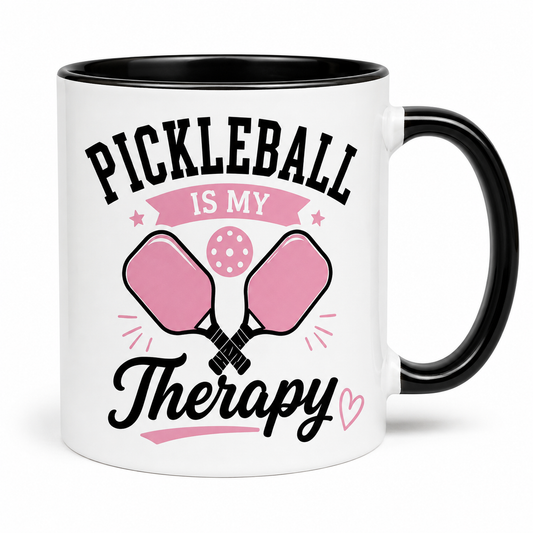 Pickleball Is My Therapy 11-ounce ceramic mug with black handle and pink paddle design on white